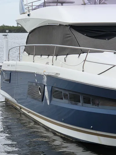  Yacht Photos Pics 2015 Prestige 450 Fly yacht with visible hull damage, docked on calm water.