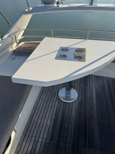  Yacht Photos Pics Flybridge table on 2015 Prestige 450 Fly yacht, overlooking calm water.