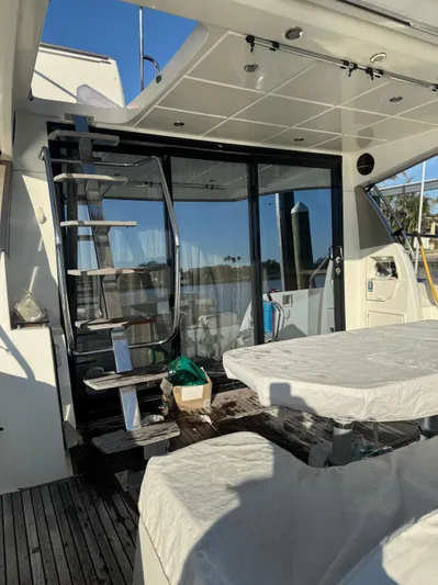  Yacht Photos Pics Prestige 450 Fly 2015 yacht deck with covered table and metal staircase.