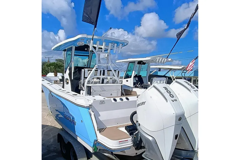 272-499 Yacht Photos Pics 2025 Blackfin 272 CC boat with dual Mercury engines, docked under a blue sky.