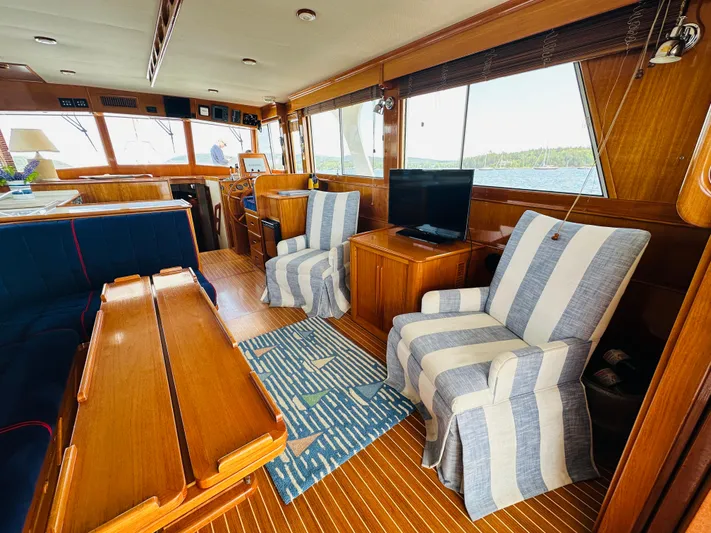 Liberty Yacht Photos Pics Interior of 2003 Grand Banks 46 Europa yacht with striped chairs and wooden furnishings.