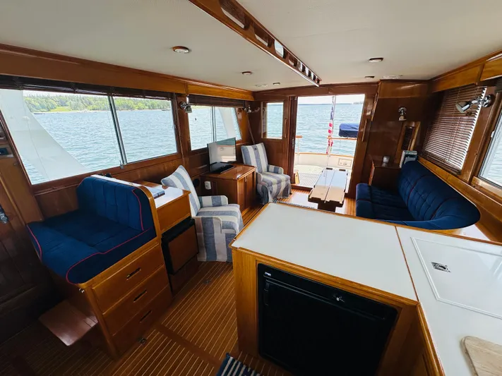 Liberty Yacht Photos Pics Interior of 2003 Grand Banks 46 Europa yacht with seating, table, and windows overlooking water.