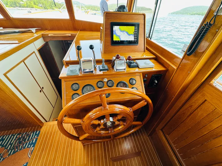 Liberty Yacht Photos Pics Helm of 2003 Grand Banks 46 Europa yacht with wooden wheel and navigation equipment.