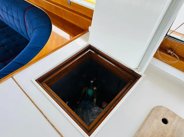 Liberty Yacht Photos Pics Open hatch on 2003 Grand Banks 46 Europa yacht interior, featuring wood and blue upholstery.
