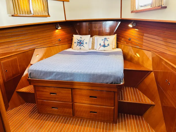 Liberty Yacht Photos Pics Luxurious cabin interior of 2003 Grand Banks 46 Europa yacht with wooden finish and cozy bedding.