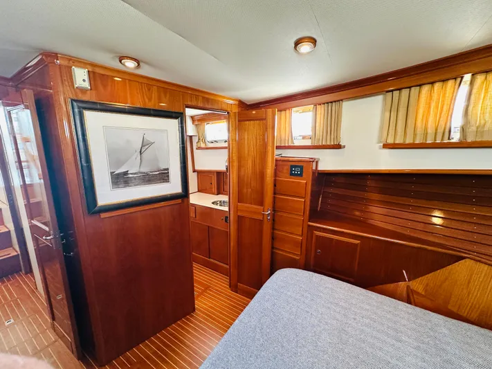 Liberty Yacht Photos Pics Luxurious 2003 Grand Banks 46 Europa yacht interior with wood paneling and cozy bedroom.