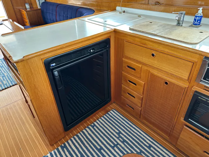 Liberty Yacht Photos Pics Interior of 2003 Grand Banks 46 Europa yacht with wooden cabinetry and compact kitchen appliances.