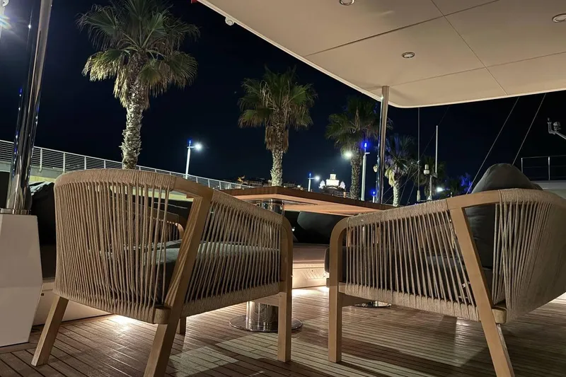 Maoria Yacht Photos Pics Luxurious Numarine 26XP yacht deck at night with elegant seating and palm trees.