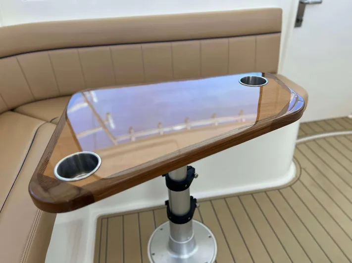  Yacht Photos Pics Henriques 42 Express Hardtop 2022 interior with wooden table and cup holders.