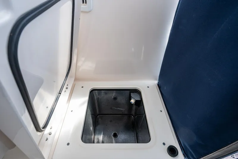  Yacht Photos Pics Open storage compartment on a Pursuit boat with a dark interior and white exterior.