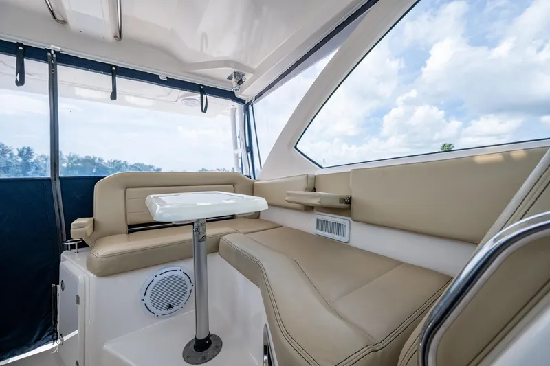  Yacht Photos Pics Luxurious Pursuit boat interior with beige seating, table, and panoramic windows.
