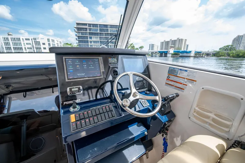  Yacht Photos Pics Helm of a Pursuit boat with modern controls and waterfront view.
