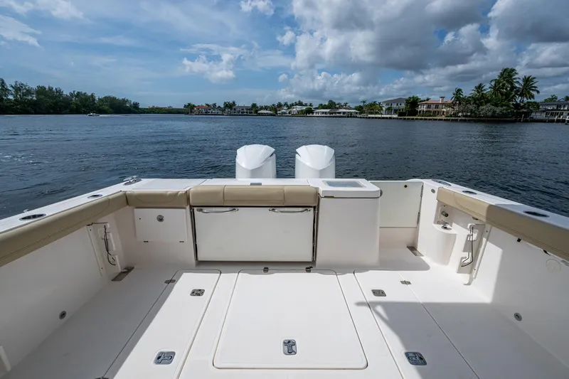  Yacht Photos Pics Spacious deck of a Pursuit boat overlooking calm waters and distant shoreline.