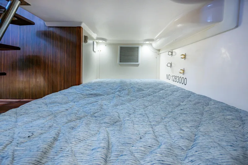  Yacht Photos Pics Cozy cabin interior with quilted bedding and wooden accents on a Pursuit boat.