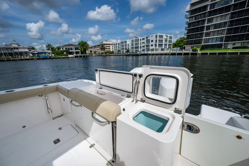 Yacht Photos Pics Pursuit boat interior with open storage, dockside view, and modern waterfront buildings.