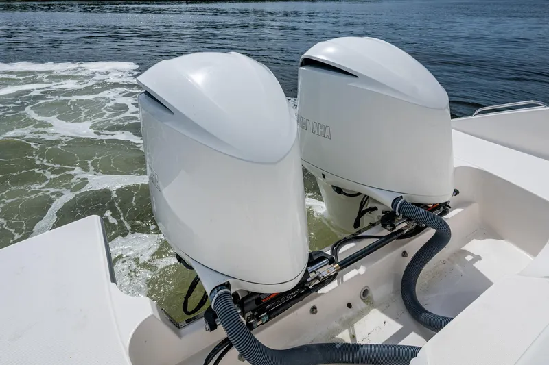  Yacht Photos Pics Twin outboard motors on a Pursuit boat, navigating through water.