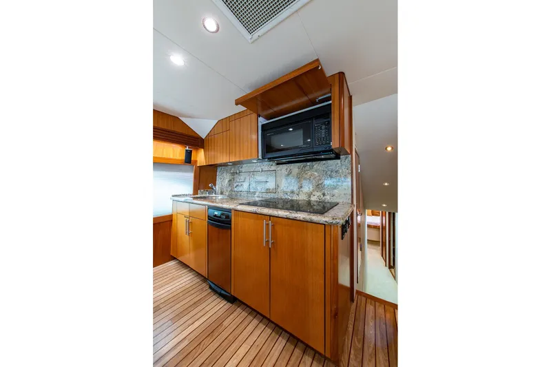  Yacht Photos Pics Luxurious kitchen interior of 2006 Hatteras 64 Convertible yacht with wood cabinetry and granite countertops.