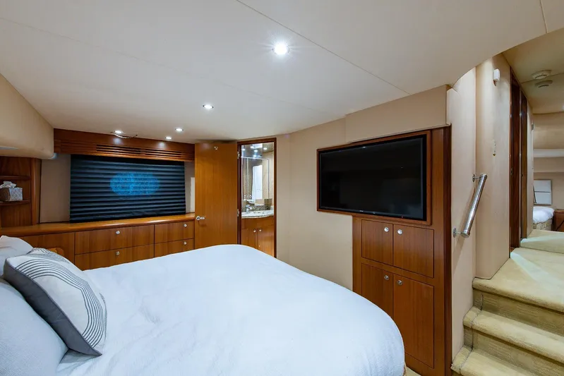  Yacht Photos Pics Luxurious bedroom interior of 2006 Hatteras 64 Convertible yacht with modern amenities.
