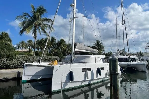 Sea Hugger Yacht Photos Pics 2016 Nautitech 40 Open catamaran docked, surrounded by palm trees and clear skies.