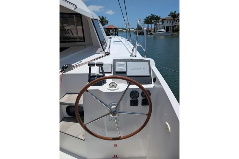 Sea Hugger Yacht Photos Pics Helm of 2016 Nautitech 40 Open catamaran with Garmin navigation system, docked by waterfront homes.