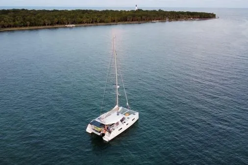 Sea Hugger Yacht Photos Pics 2016 Nautitech 40 Open catamaran sailing near a lush island coastline.