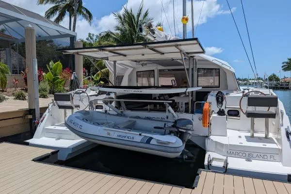 Sea Hugger Yacht Photos Pics Nautitech 40 Open 2016 catamaran docked at Marco Island, featuring a dinghy and tropical backdrop.