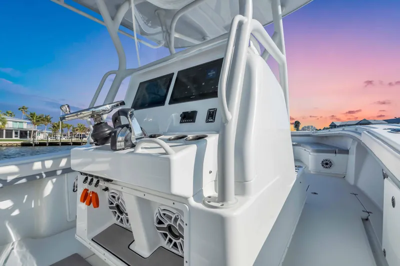  Yacht Photos Pics 2021 Yellowfin 36 Offshore boat console at sunset, featuring modern controls and speakers.