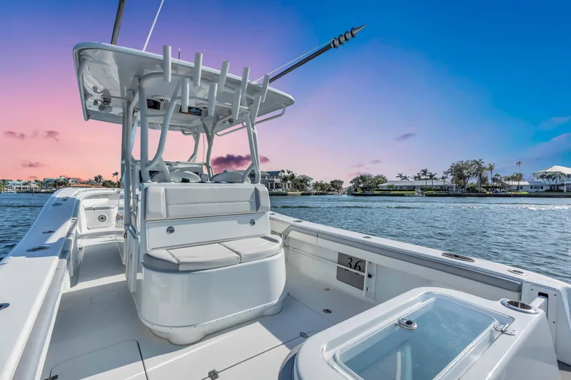  Yacht Photos Pics 2021 Yellowfin 36 Offshore boat on water at sunset, showcasing sleek design and spacious deck.