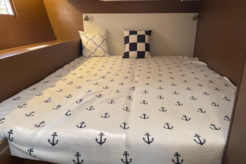Show Boat! Yacht Photos Pics Cozy cabin bed in 2024 Beneteau Oceanis 51.1 yacht with nautical-themed bedding.