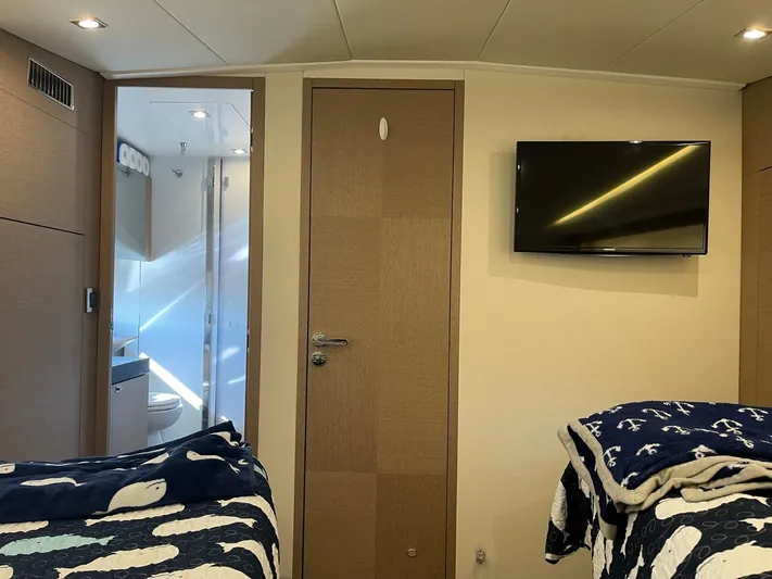  Yacht Photos Pics Interior of 2018 Prestige 500 S yacht cabin with twin beds and wall-mounted TV.
