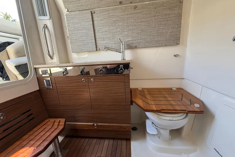 Gail Force Yacht Photos Pics 2023 Boston Whaler 360 Outrage interior with wooden cabinetry and compact marine toilet.