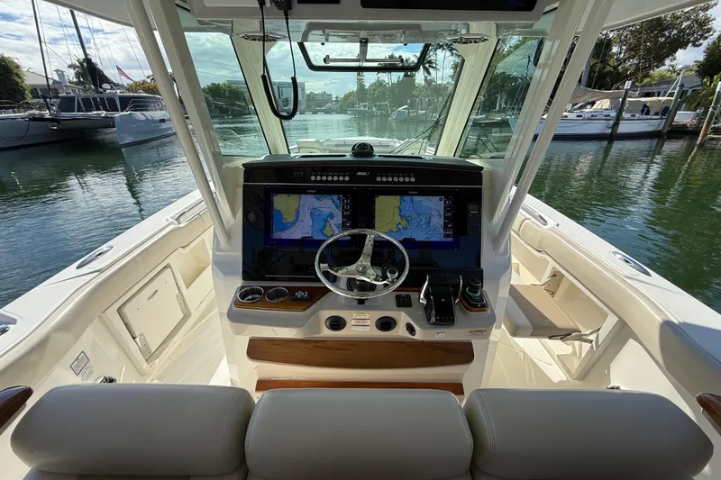 Gail Force Yacht Photos Pics 2023 Boston Whaler 360 Outrage helm with advanced navigation system, docked in a marina.