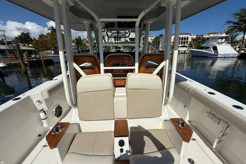 Gail Force Yacht Photos Pics 2023 Boston Whaler 360 Outrage boat interior with seating and cup holders, docked in marina.