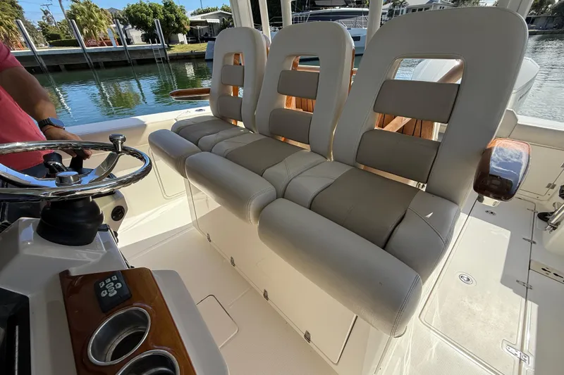 Gail Force Yacht Photos Pics 2023 Boston Whaler 360 Outrage boat interior with cushioned seating and steering wheel.