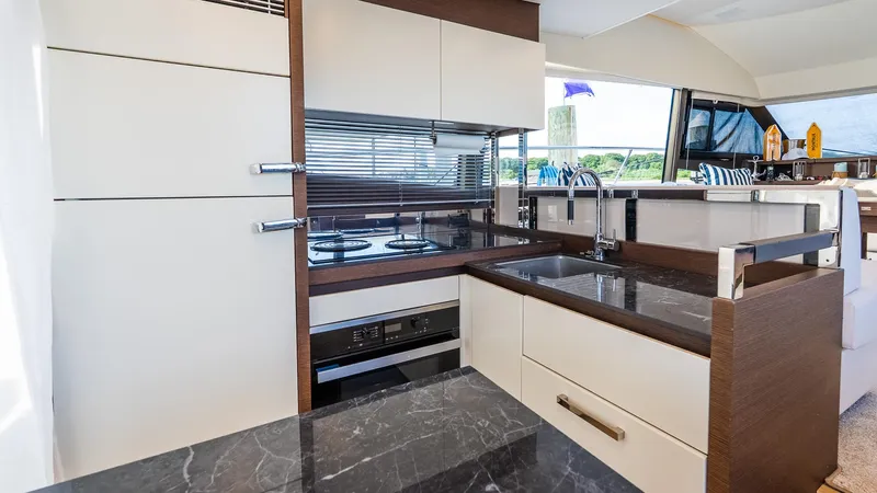  Yacht Photos Pics Luxurious kitchen interior of 2019 Prestige 520 Flybridge yacht with modern appliances and sleek design.