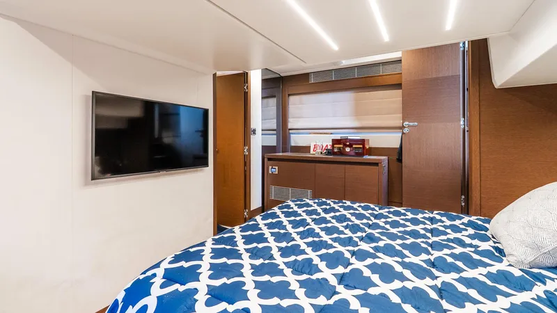  Yacht Photos Pics Luxurious bedroom interior of 2019 Prestige 520 Flybridge yacht with modern decor and TV.