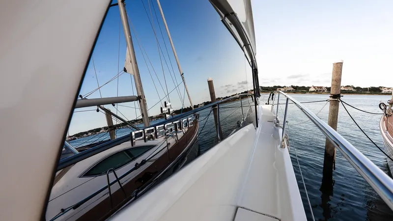  Yacht Photos Pics 2019 Prestige 520 Flybridge yacht reflecting on calm water at a marina.