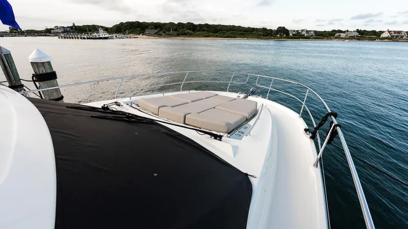  Yacht Photos Pics 2019 Prestige 520 Flybridge yacht docked by serene waters, featuring spacious sunbathing area.