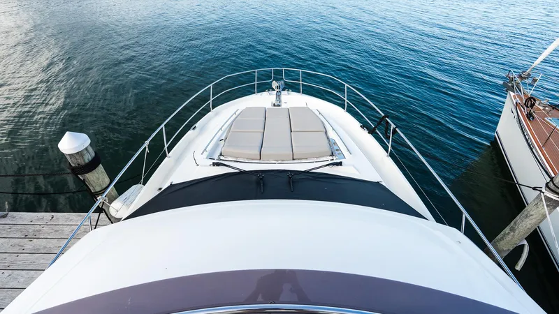  Yacht Photos Pics 2019 Prestige 520 Flybridge yacht docked, featuring spacious sunbathing area on calm water.
