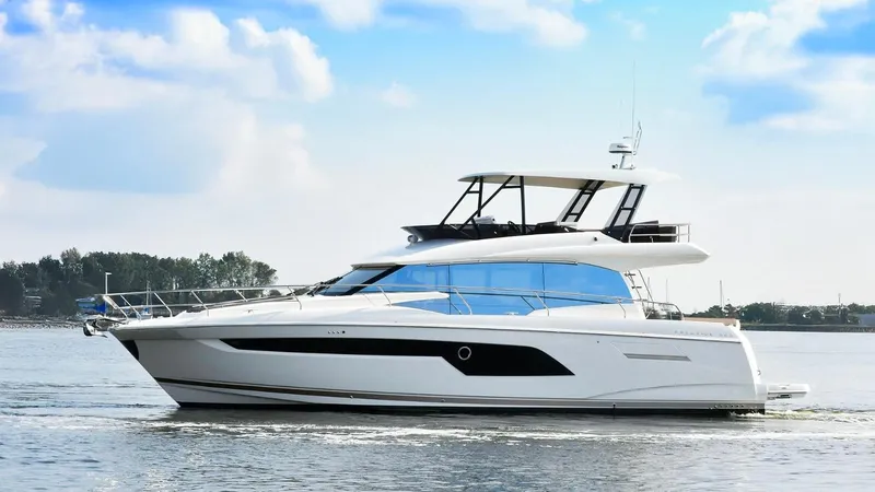  Yacht Photos Pics 2019 Prestige 520 Flybridge yacht cruising on calm waters under a blue sky.