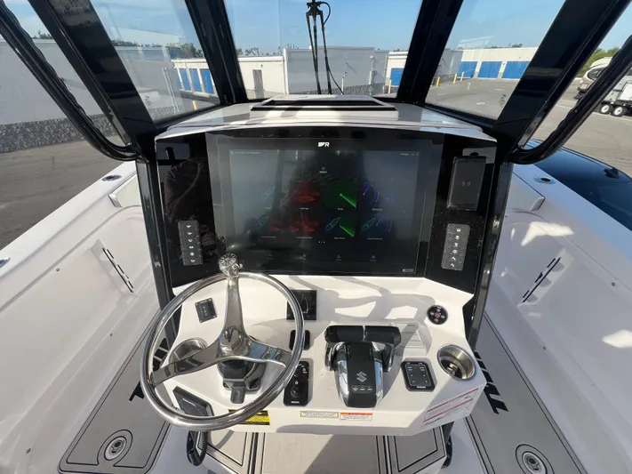  Yacht Photos Pics 2025 Twin Vee 280 GFX2 CC boat console with steering wheel and navigation display.