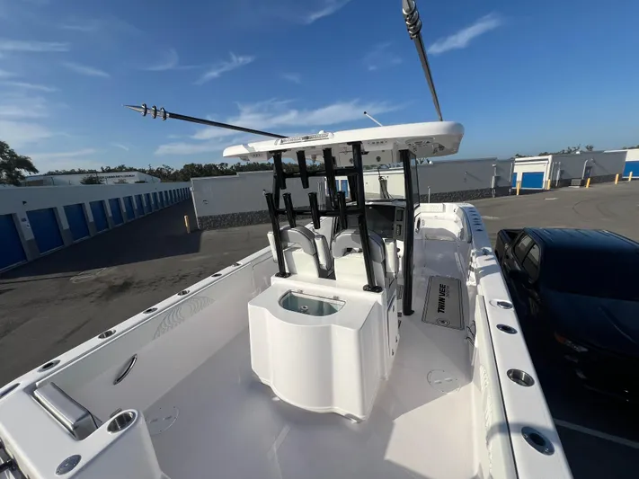 Yacht Photos Pics 2025 Twin Vee 280 GFX2 CC boat with fishing rod holders, docked in a storage facility.