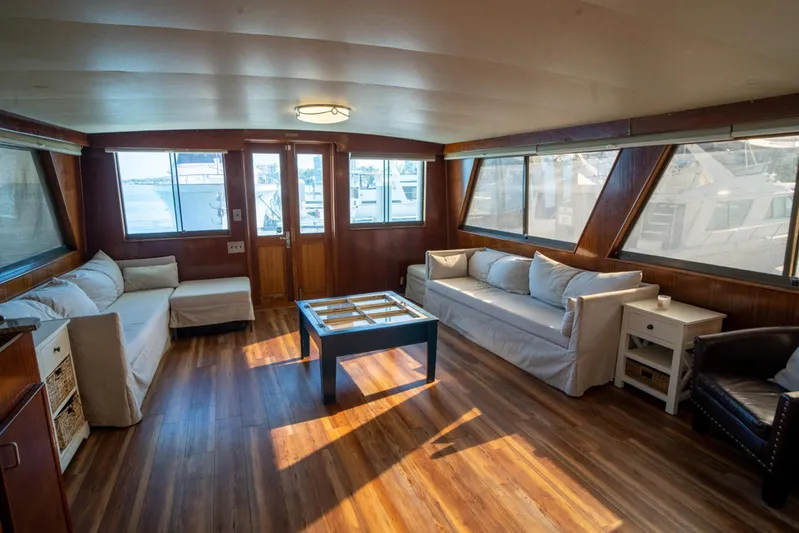 Hattrick Yacht Photos Pics Spacious interior of 1981 Hatteras 61 Cockpit MY yacht with sofas and large windows.