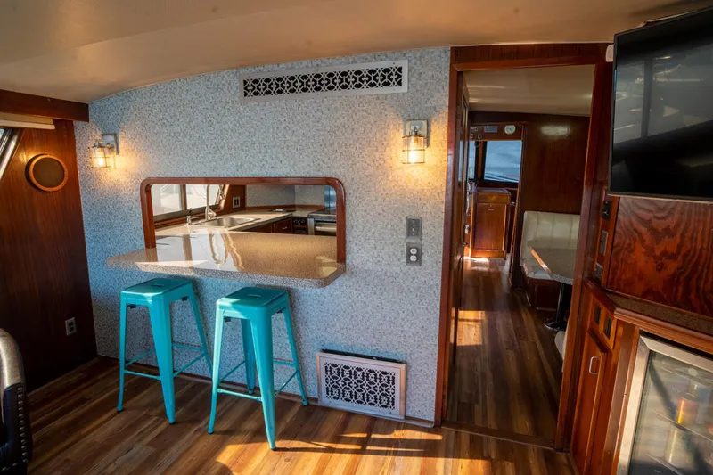 Hattrick Yacht Photos Pics Interior of 1981 Hatteras 61 Cockpit MY yacht with bar stools and wood flooring.