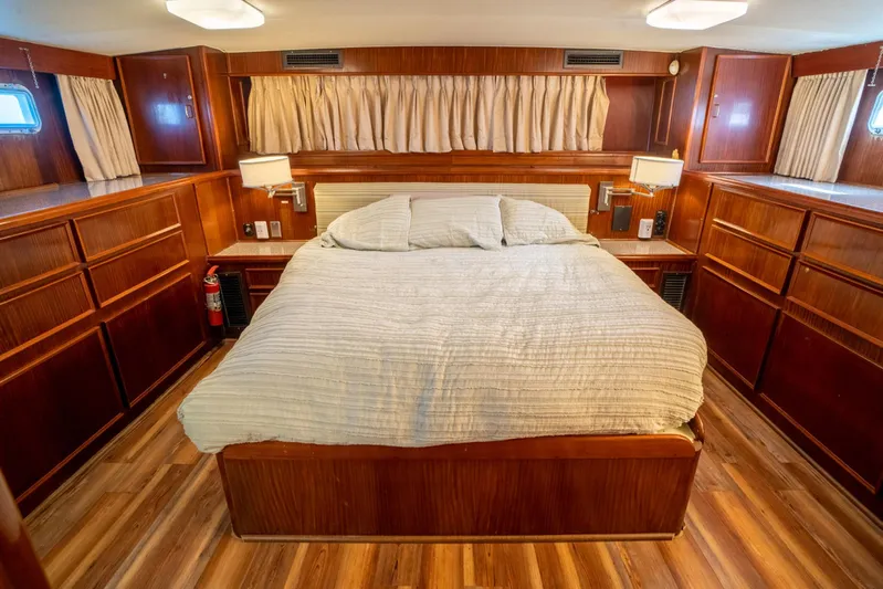 Hattrick Yacht Photos Pics Luxurious 1981 Hatteras 61 Cockpit MY bedroom with wood paneling and cozy bedding.