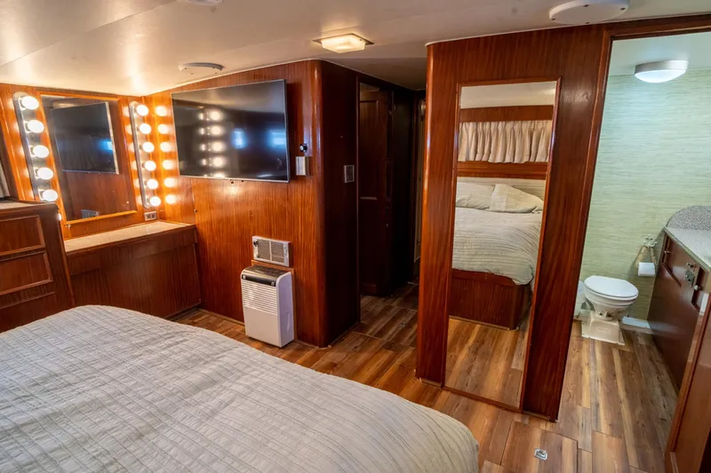Hattrick Yacht Photos Pics Luxurious 1981 Hatteras 61 Cockpit MY yacht bedroom with wood paneling and ensuite bathroom.