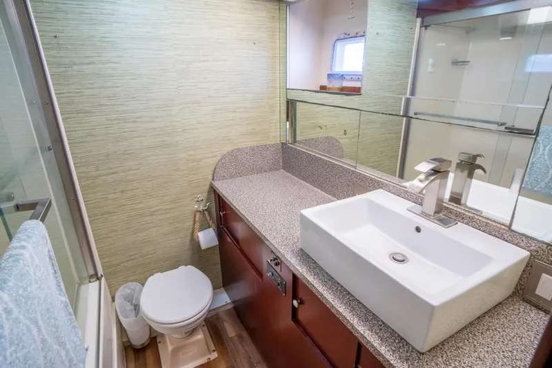 Hattrick Yacht Photos Pics Luxurious bathroom in 1981 Hatteras 61 Cockpit MY yacht with modern sink and fixtures.