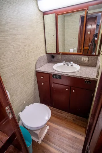 Hattrick Yacht Photos Pics 1981 Hatteras 61 Cockpit MY bathroom with sink, mirror, and toilet.