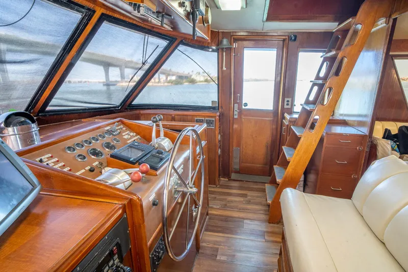 Hattrick Yacht Photos Pics 1981 Hatteras 61 Cockpit MY interior with wooden helm, steering wheel, and seating area.