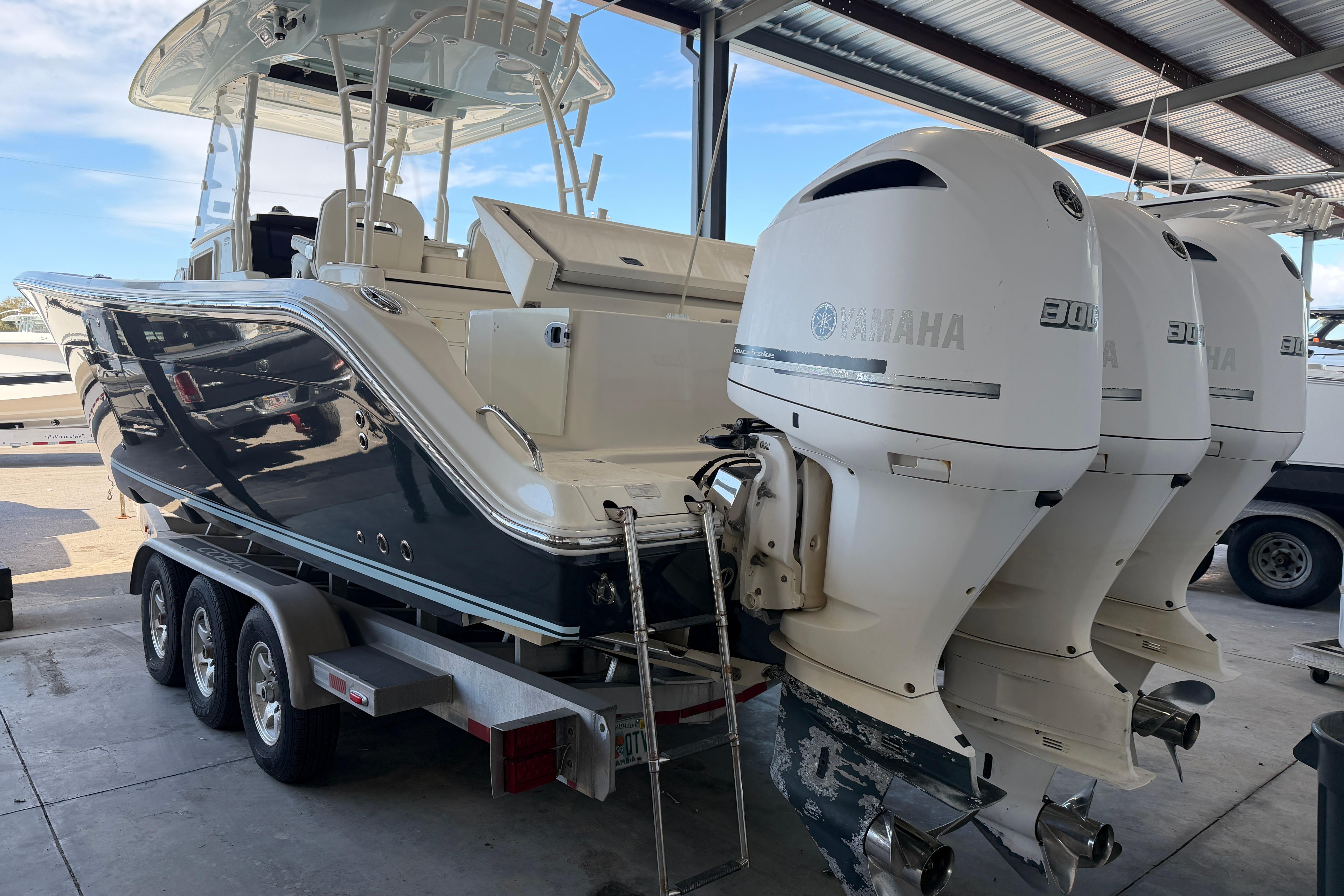 2015 Cobia 344 Center Console boat with triple Yamaha engines on trailer.